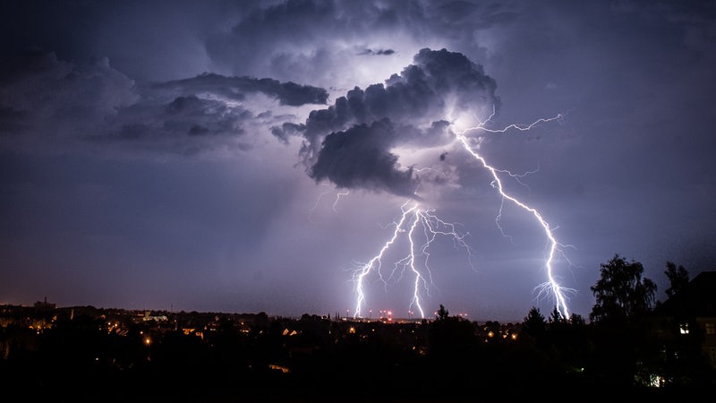 Viele Blitze gehen aus einer Gewitterwolke herunter.