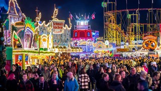 Die Fahrgeschäfte auf dem zuvor eröffneten Freimarkt auf dem Bürgerweide leuchten mit bunten Lichtern und Reklameschriftzügen. Der Bremer Freimarkt ist eines der ältesten Volksfeste Deutschlands und das größte im Norden. Bis zum 30. Oktober findet er auf auf der Bürgerweide und in der Bremer Innenstadt statt.