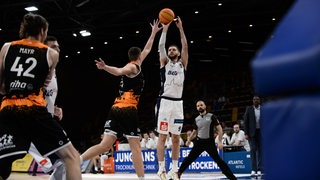 Basketball-Profi Matthew Freeman von den Eisbären Bremerhaven reckt sich zum Wurf.