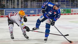 Zwei Eishockeyspieler kämpfen um den Puck.