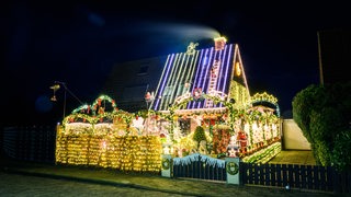 Zu sehen ist das beleuchtete Weihnachtshaus in Delmenhorst. Mit rund 60 000 Lichtern hat ein Ehepaar sein Haus und Grundstück weihnachtlich geschmückt. 