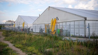 Zelte zur Unterbringung von Geflüchteten stehen in der Überseestadt, angrenzend sollen zukünftig winterfeste Leichtbauhallen aufgebaut werden.