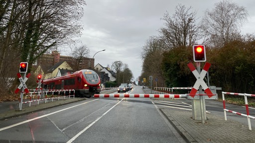 Ein Zug der Deutschen Bahn fährt an einem Bahnübergang vorbei.