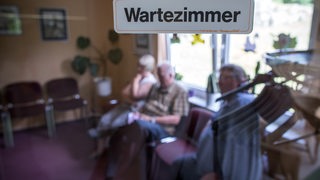 Patienten sitzen im Wartezimmer de Arztpraxis 