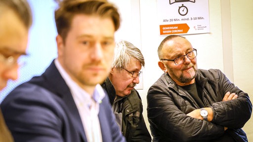 Das Mitglied des Notvorstandes der Bremer AfD, Frank Magnitz (r), sitzt bei der Sondersitzung des Wahlbereichsausschusses Bremen zur Bürgerschaftswahl im Statistischen Landesamt Bremen im Publikum hinter der Vertrauensperson der Bremer AfD, Sergej Minich (2.v.l.). In der zerstrittenen Bremer AfD haben zwei Lager jeweils eine eigene Liste für die Bürgerschaftswahl am 14. Mai 2023 aufgestellt. Der Wahlbereichsausschuss soll in öffentlicher Sitzung die Sachlage prüfen.