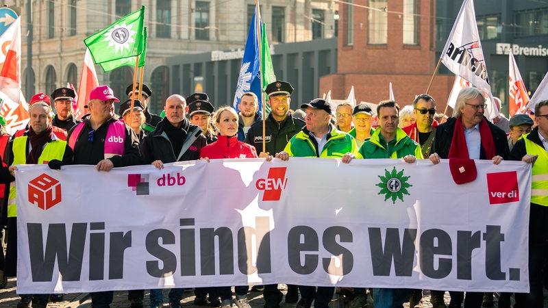 Streikende zeigen ein Transparent mit der Aufschrift "Wir sind es wert"