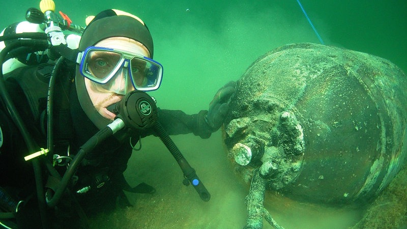 Ein Taucher neben einer Bombe im Meer