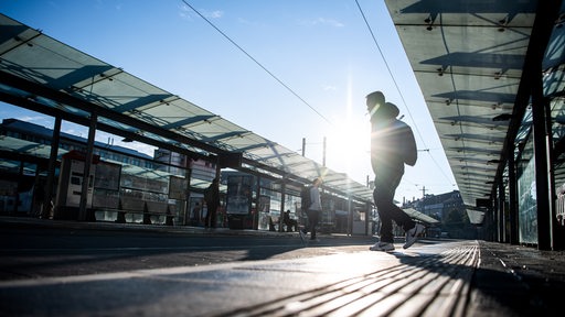 Eine Person läuft über die Gleise der Straßenbahnhaltestelle vor dem Bremer Hauptbahnhof.