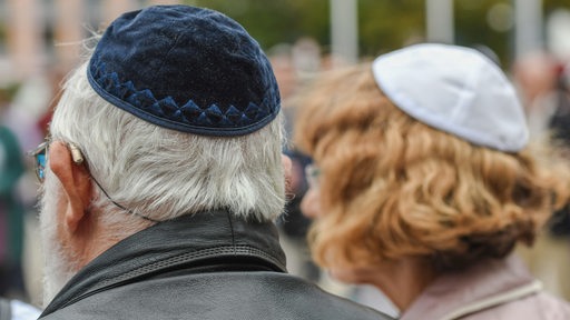 Ein Mann und eine Frau mit Kippa auf dem Kopf sind von hinten zu sehen.