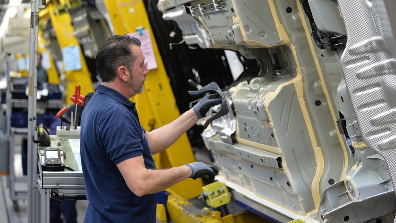 Ein Mann steht an einer großen Maschine im Mercedes-Werk in Bremen