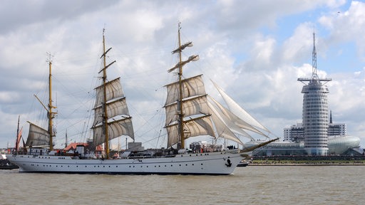 Als Führungsschiff der Einlaufparade zum Windjammertreffen "Sail 2010" passiert die Dreimastbark "Gorch Fock" der Deutschen Marine am Mittwoch (25.08.2010) das Klimahaus und das Sail City Hotel der Havenwelten in Bremerhaven.