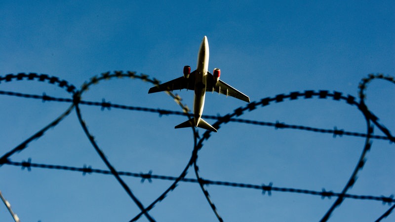 Ein Flugzeug einem Flughafen hinter Stacheldraht