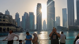 Touristen vor der Wolkenkratzerkulisse am Lake Burj Khalifa. Dubai, Vereingte Arabische Emirate