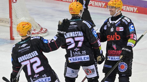 Eishockey-Spieler der Fischtown Pinguins kommen nach einem Tor zusammen und klatschen den Torschützen ab.