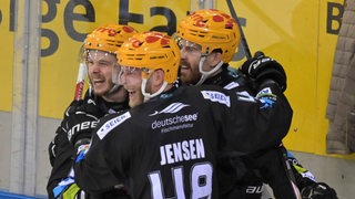 Drei Spieler der Fischtown Pinguins bejubeln einen Treffer auf dem Eishockeyfeld.