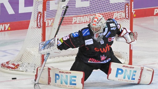 Maximilian Franzreb, Torwart der Pinguins, hütet sein Tor, indem er seine Körperfläche verbreitert.