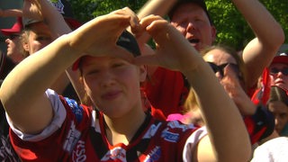 Eishockey-Fans der Fischtown Pingiuns formen mit der Hand ein Herz bei der Saisonabschlussfeier.