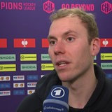 Eishockey-Torwart Maximilian Franzreb von den Fischtown Pinguins steht nach einem Champions-League-Spiel vor einer Werbewand beim Interview.