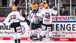 Jubel bei den Eishockey-Spielern der Fischtown Pinguins, die zur Gruppenumarmung auf dem Eis zusammenkommen nach einem Treffer.