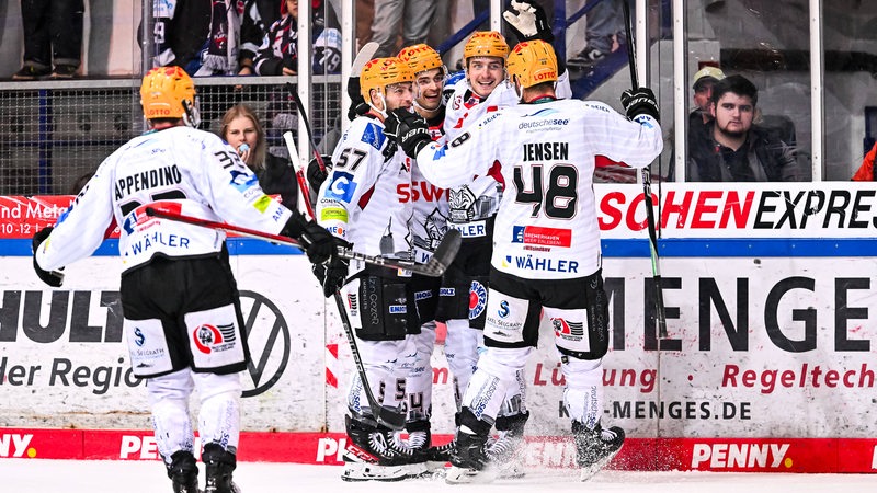 Jubel bei den Eishockey-Spielern der Fischtown Pinguins, die zur Gruppenumarmung auf dem Eis zusammenkommen nach einem Treffer.