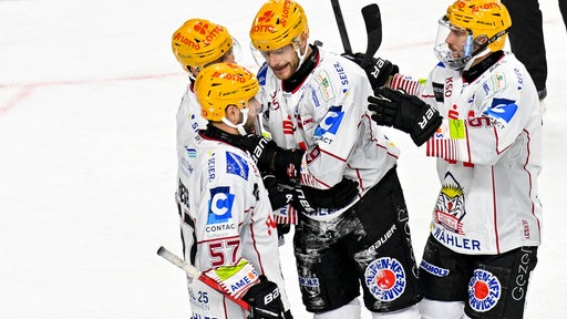 Eishockey-Spieler der Fischtown Pinguins kommen nach einem Treffer zusammen und klatschen sich jubelnd ab.