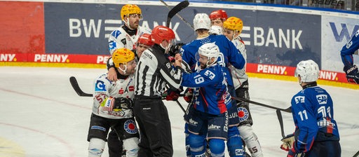 Eishockey-Spieler der Fischtown Pinguins geraten mit Spielern der Adler Mannheim aneinander und liefern sich ein Handgemenge auf dem Eis.