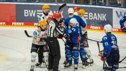 Eishockey-Spieler der Fischtown Pinguins geraten mit Spielern der Adler Mannheim aneinander und liefern sich ein Handgemenge auf dem Eis.