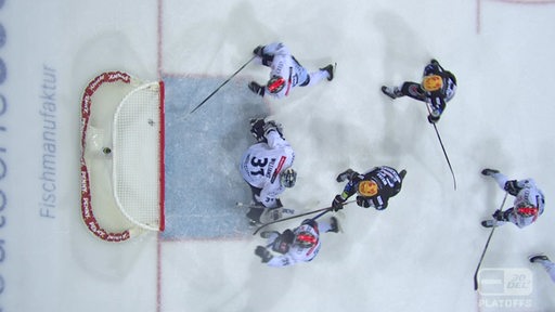 Blick von oben auf die Eisfläche, wo Eishockey-Spieler der Fischtown Pinguins den Puck ins Tor der Ingolstädter schieben.