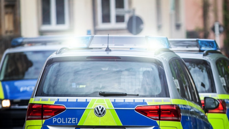 Einsatzfahrzeug der Polizei stehen auf einer Straße.