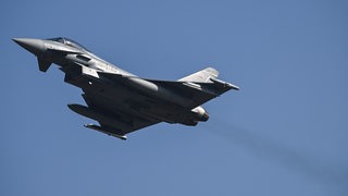 Ein Bundeswehr-Flugzeug vom Typ "Eurofighter" fliegt durch den blauen Himmel