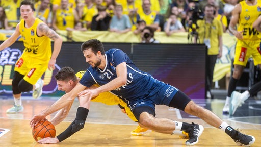 Ein Spieler der MLP Academics Heidelberg und ein Spieler der EWE Baskets Oldenburg kämpfen um den Ball.