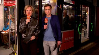 Die Moderatoren Kirsten Rademacher und Felix Krömer vor einer Straßenbahn in Bremen