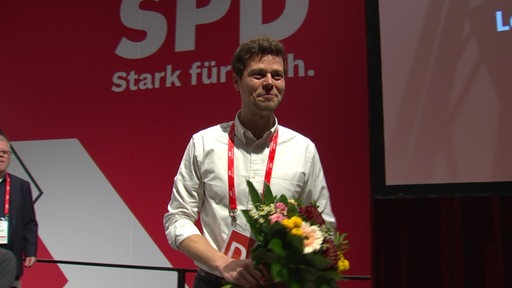 Der SPD Politiker Falk Wagner mit einem Blumenstrauß in der Hand