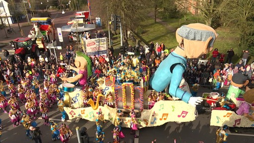 Ein Faschingsumzugswagen in Ganderkesee mit zwei großen Figuren drauf.