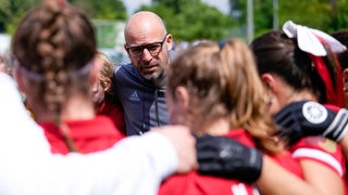 Die Bremer Hockey-Spielerinnen des BHC stehen nach dem Spiel im Kreis um Trainer Florian Keller herum.