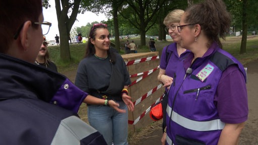 Ein Mädchen spircht mit drei Frauen von der Festivalseelsorge.