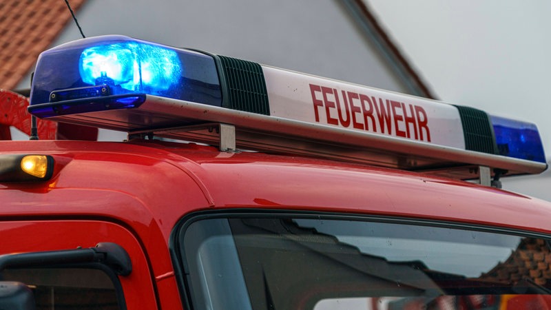 Ein Feuerwehrauto steht vor einem Haus.