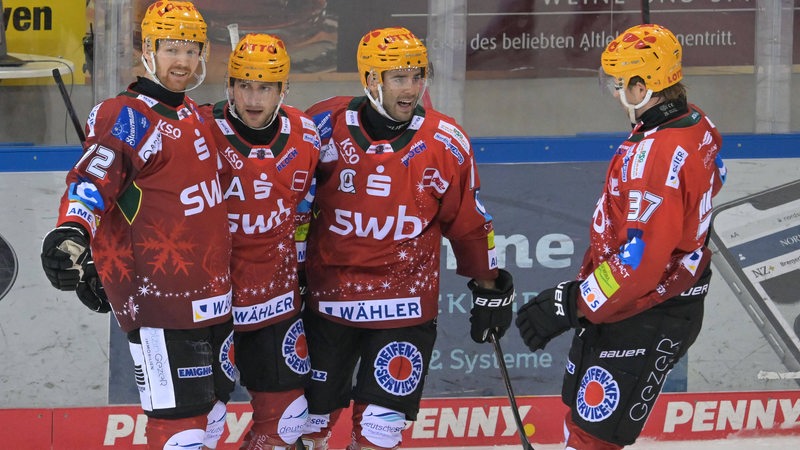 Spieler der Fischtown Pinguins in roten Trikots jubeln über ein Tor.