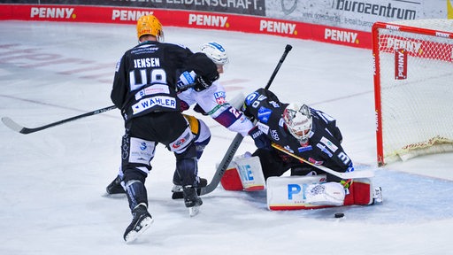 Der Torhüter der Fischtown Pinguins greift unter Bedrängnis nach dem Puck.