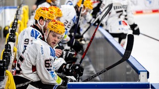 Ein Spieler der Fischtown Pinguins sitzt auf der Bank und schaut erschöpft zur Seite.