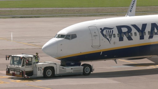 Es ist ein Flugzeug und ein Wagen auf einer Landebahn zu sehen.