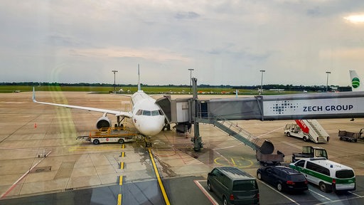 Ein Flugzeug steht an einer Passagierbrücke