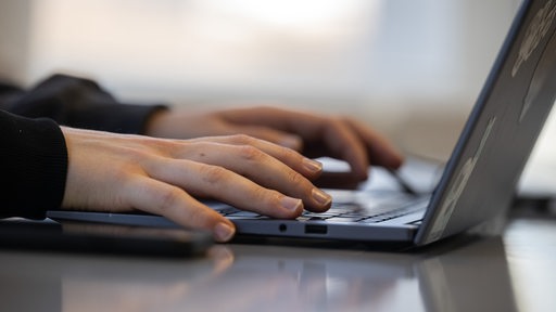 Eine Frau arbeitet an einem Laptop.