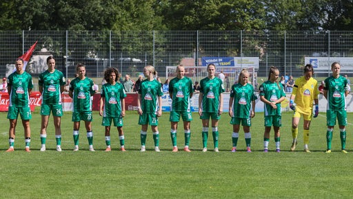 Die Fußballerinnen von Werder Bremen stehen aufgereiht nebeneinander vor einem Testspiel.