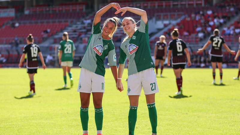 Die Werder Fußballerinnen Maja Sternad und Nina Lührßen formen nach dem Tor gegen Nürnberg mit ihren Armen ein Herz auf dem Platz.