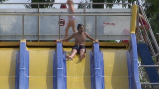 Kinder im Freibad am Rutschen.