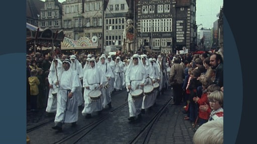 Archivaufnahme einer Gruppe weiß bekleideter Menschen mit Trommeln auf dem Bremer Freimarktsumzug