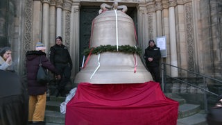 Die neue Friedensglocke steht auf einem Podest, vor den Stufen des Bremer Doms.