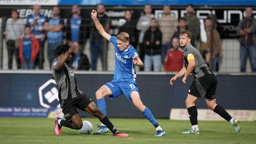 Zwei Spieler des Bremer SV im Zweikampf mit einem Spieler des SV Meppen. 