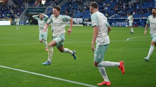 Werder-Spieler Jens Stage rennt jubelnd übers Feld nach seinem Treffer gegen Hoffenheim, seine Mitspieler folgen ihm.